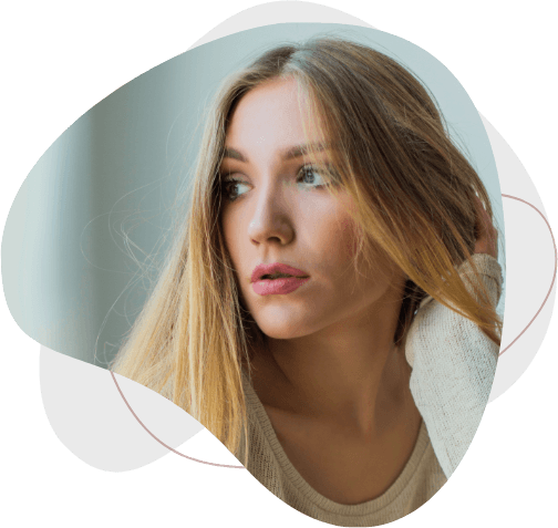 Young blonde woman sitting next to window