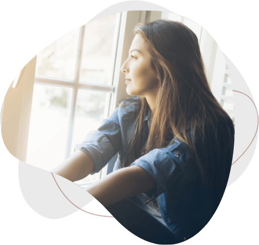 Young woman sitting and looking through window