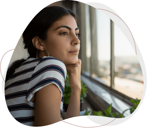 Thoughtful woman looking through window at office